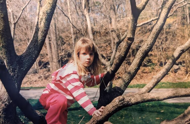 The author at age seven, climbing a tree