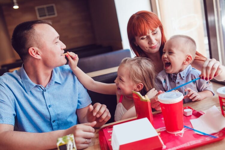 A family eating fast food together in a booth
