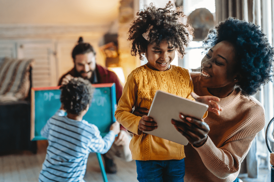 A family using a tablet as part of the home classroom.