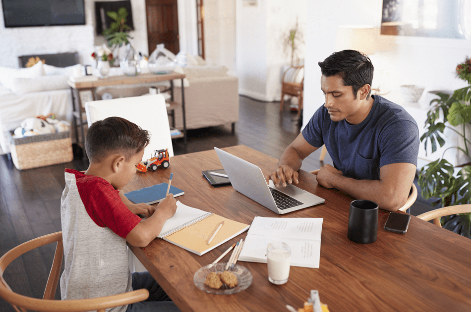 Father and son sharing a table to work and attend school remotely