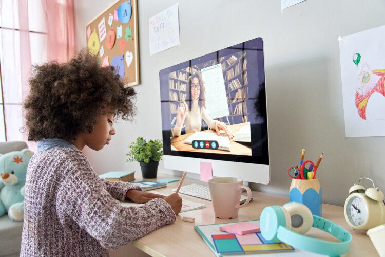 African school kid girl distance learning with online teacher at home.
