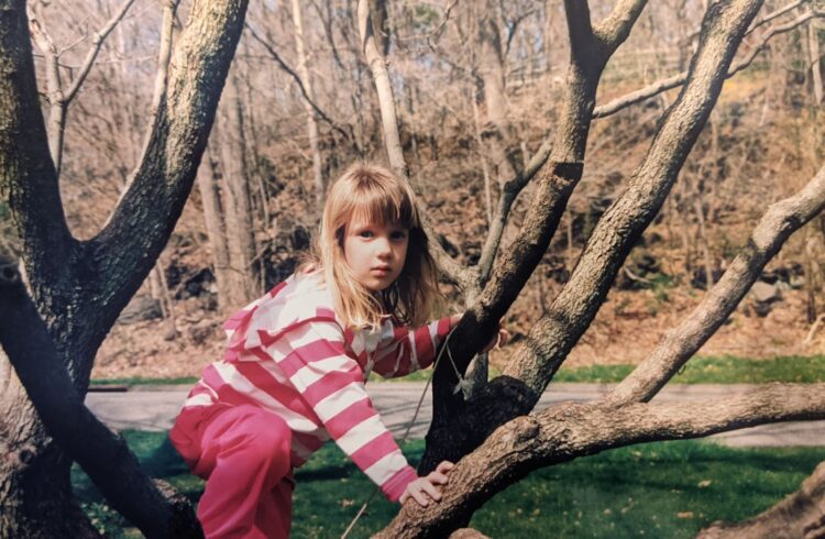 The author at age seven, climbing a tree