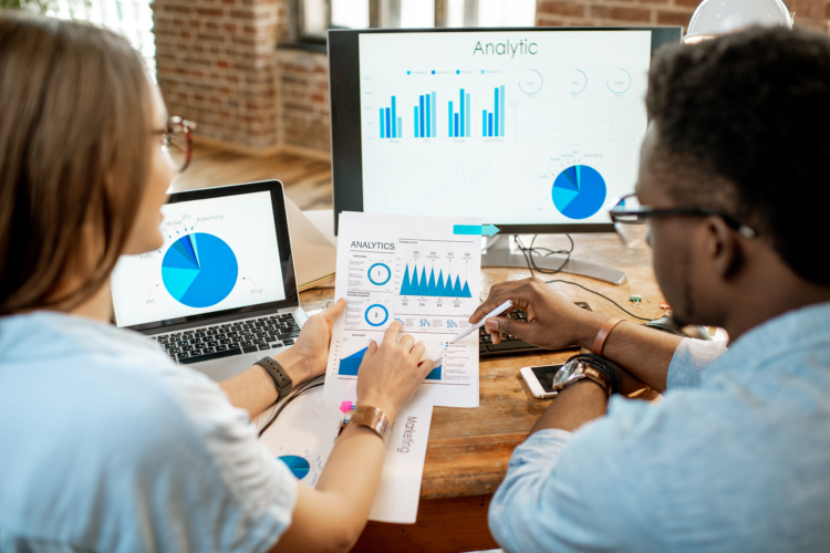 two co workers looking at data outputs in the form of charts