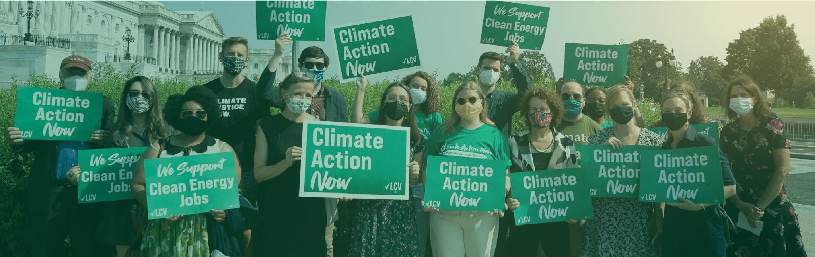 A photo of a group of activists in front of Congress holding "Climate Action Now" signs