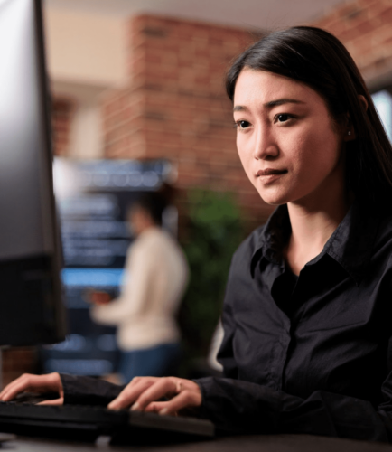 young woman typing at a computer screen