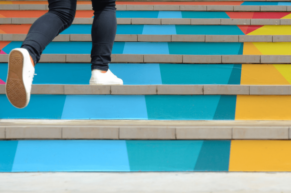 Photo of a person climbing colorful steps